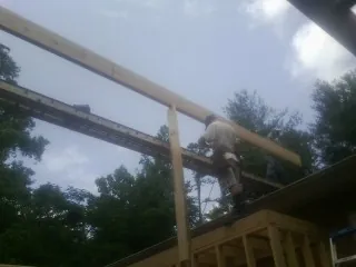 Carpenter setting a ridge beam over a new addition frame — Ice Dam Removal by Roofing Brothers in Farmersville