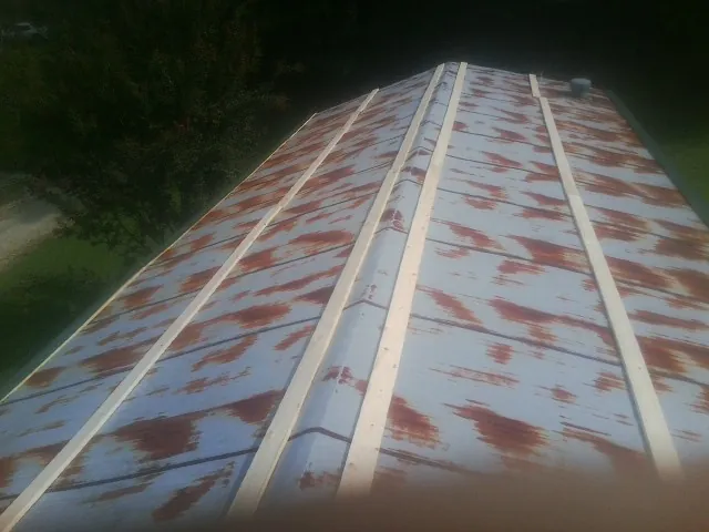 Rusted metal roof panels with new wood purlins before replacement — Storm Damage Roof Repair in Farmersville by Roofing Brothers